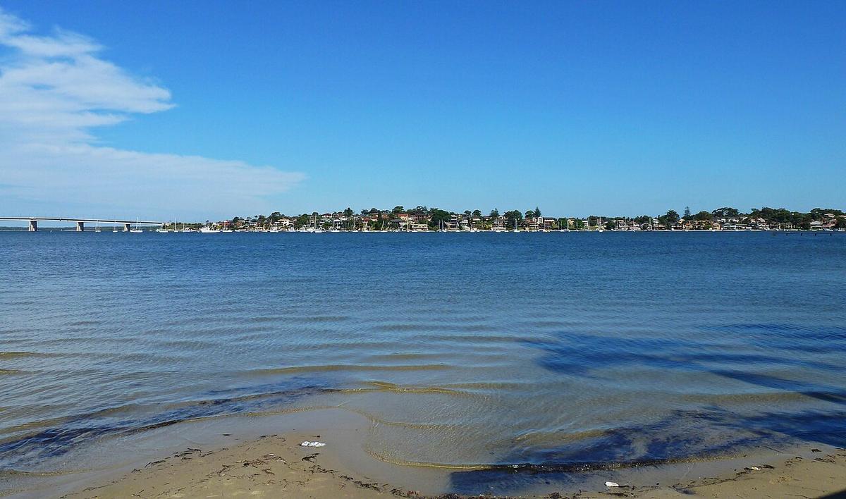 The Georges River from Marra Place at Sylvania, Sydney, with a sandy shore and a bridge on the far left