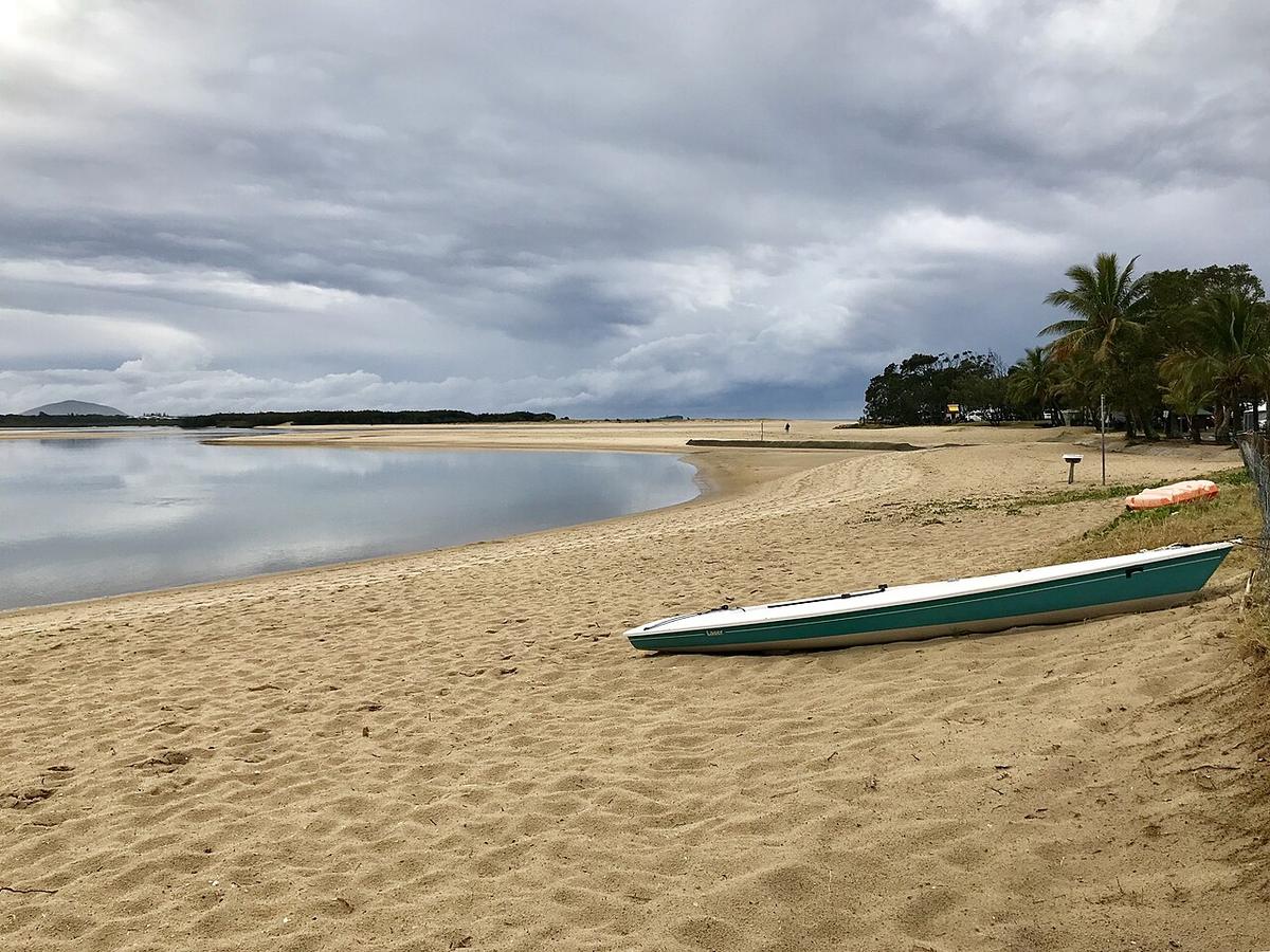 The sandy bank of the Maroochy River estuary at Cotton Tree on the Sunshine Coast, Queensland, under a grey sky